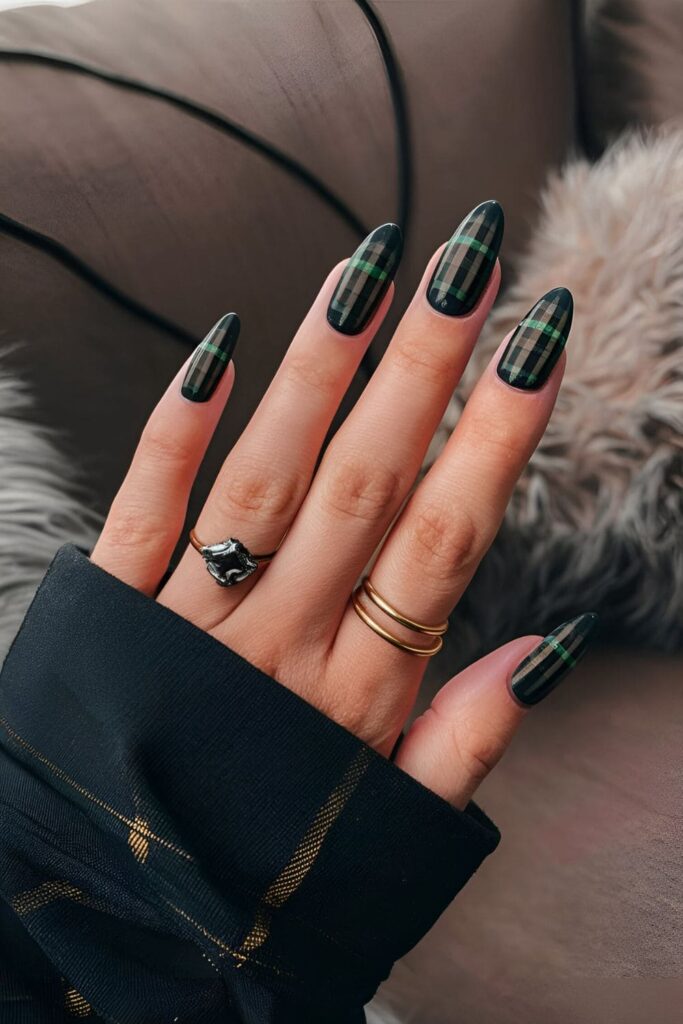 Nails featuring a grunge-inspired plaid pattern in dark colors like black, dark green, and burgundy, with a matte finish and distressed lines