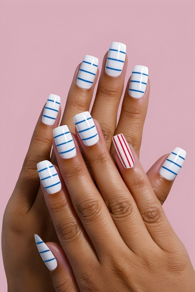 Nails painted to look like lined notebook paper, featuring a white base with blue horizontal lines and a red vertical margin line