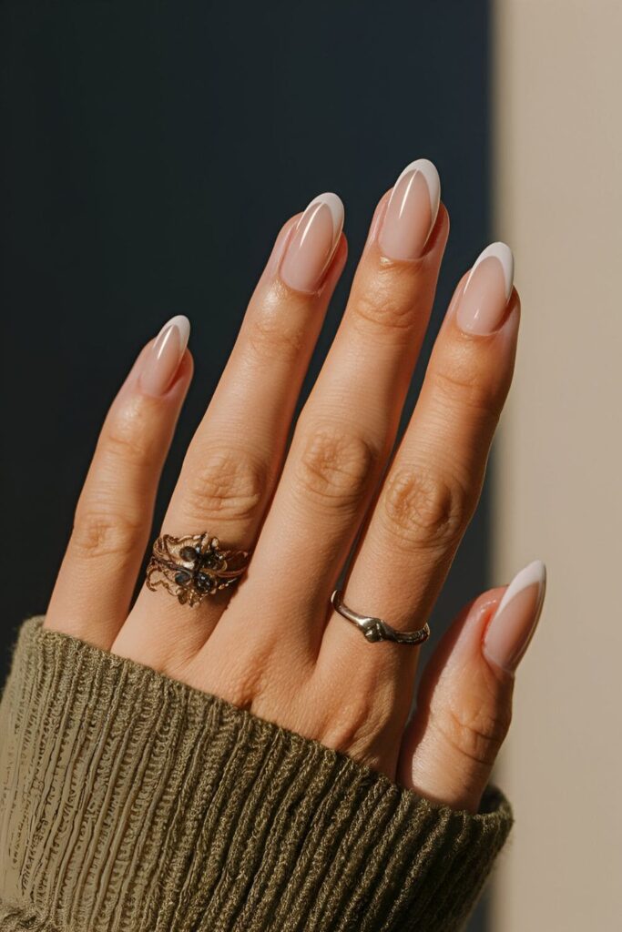 Nails using the natural nail color as part of the design, with interesting shapes and patterns created by leaving parts unpainted