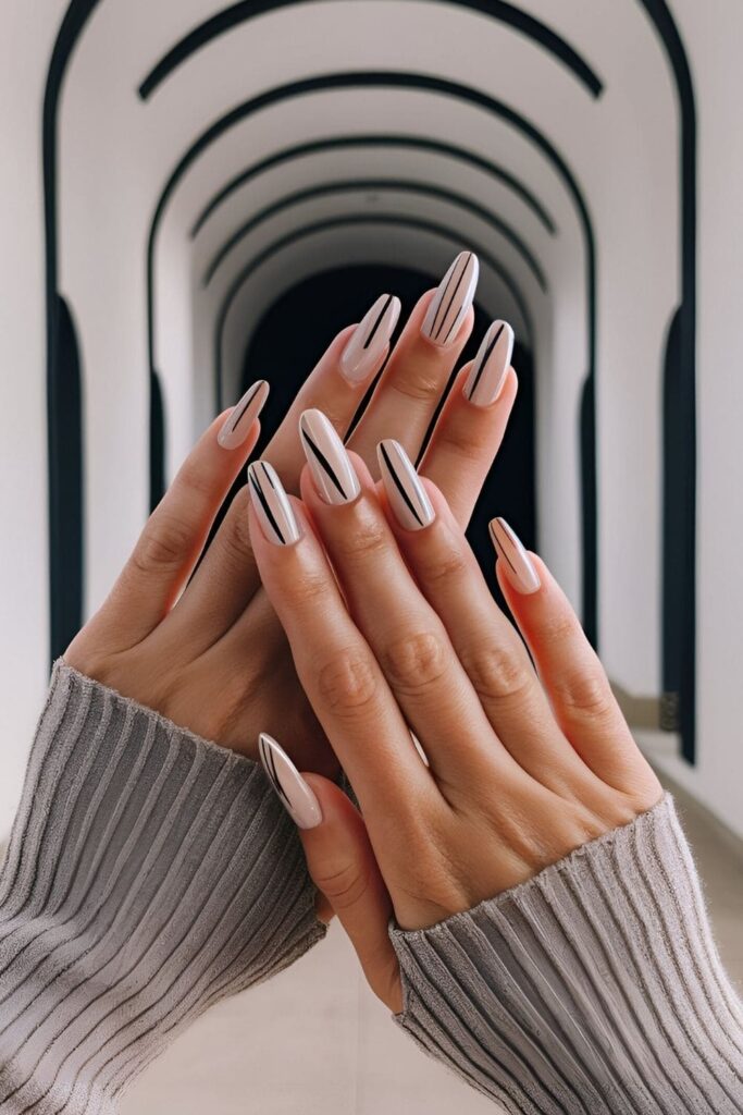 Nails with a neutral base and delicate thin lines in black, white, or metallic shades, arranged horizontally, vertically, or diagonally


