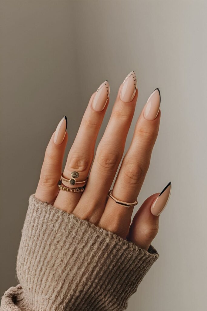 Nails with a neutral base color adorned with simple shapes like dots, lines, and triangles in black or metallic shades for a modern and chic look