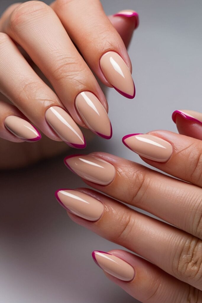 Nails with a nude base and small triangle shapes at the tips in a contrasting color for a sleek and geometric look