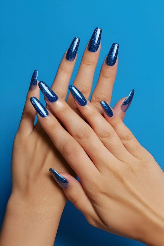 Nails-with-a-solid-blue-base-and-blue-glitter-added-to-the-tips-for-a-subtle-sparkle-and-glamorous-look