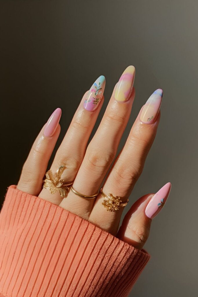 Nails with a watercolor effect in pastel colors, blending together softly, adorned with floral designs for a delicate look