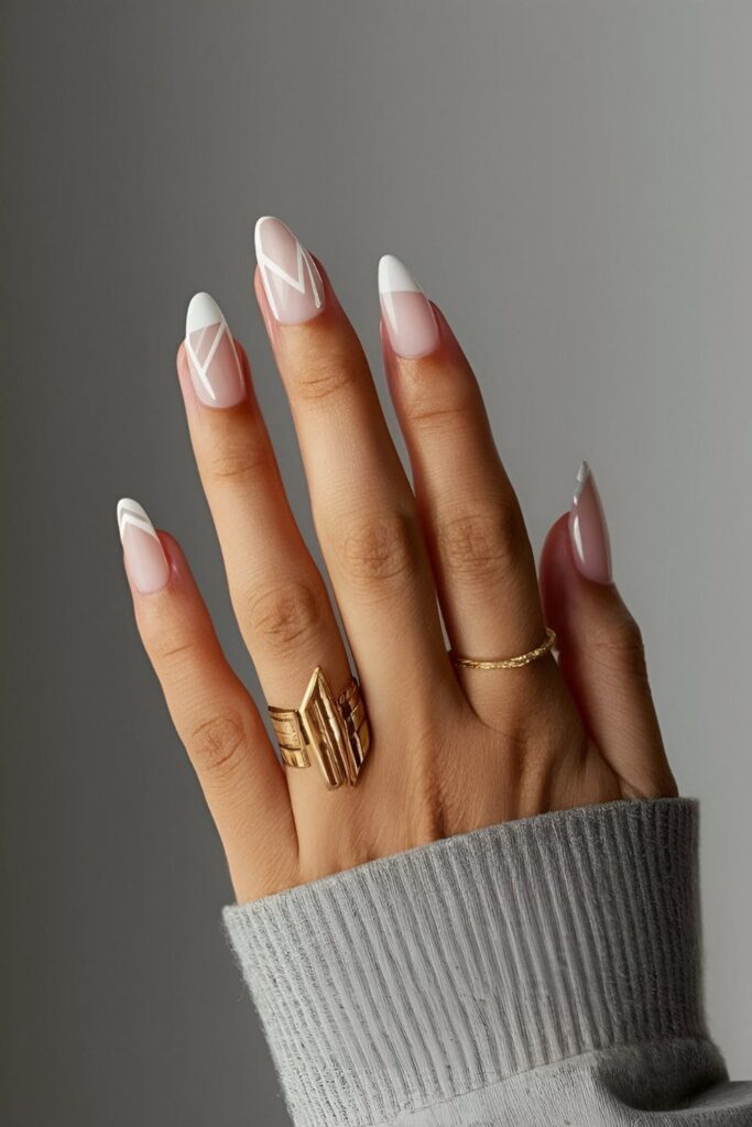 Nails with geometric cut-out designs like triangles and rectangles revealing negative space on a minimalist base