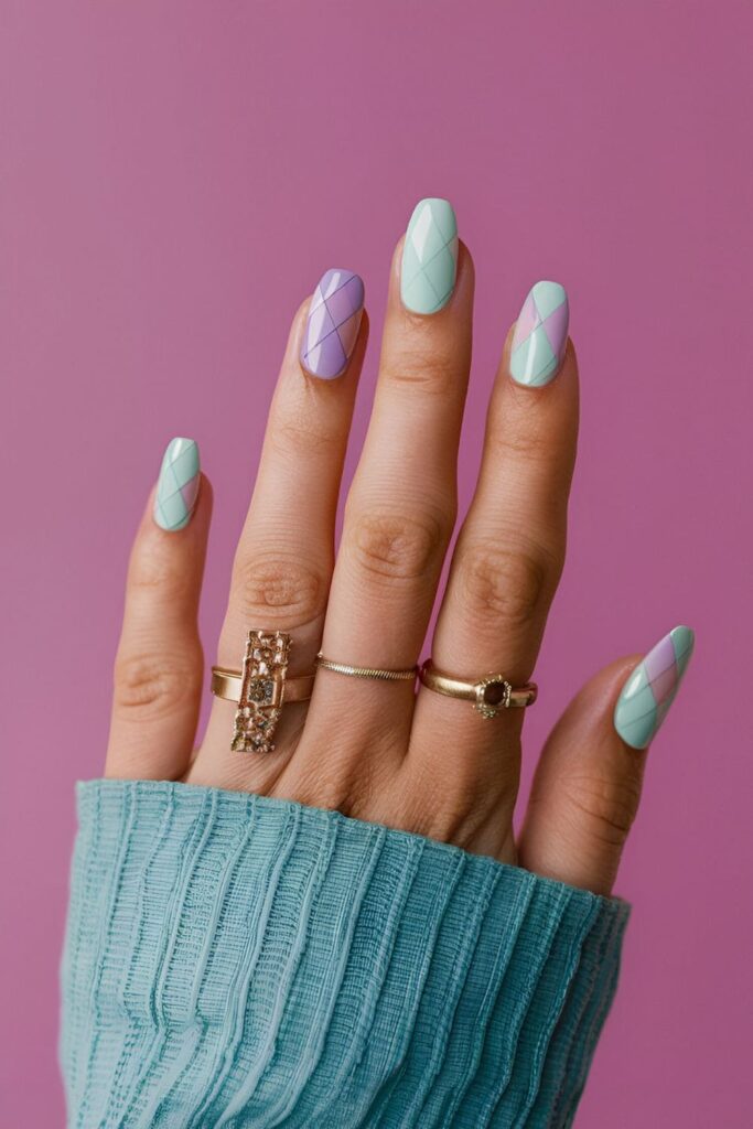 Nails with geometric patterns in pastel colors, including pink, blue, lavender, and mint, creating triangles, squares, or hexagons