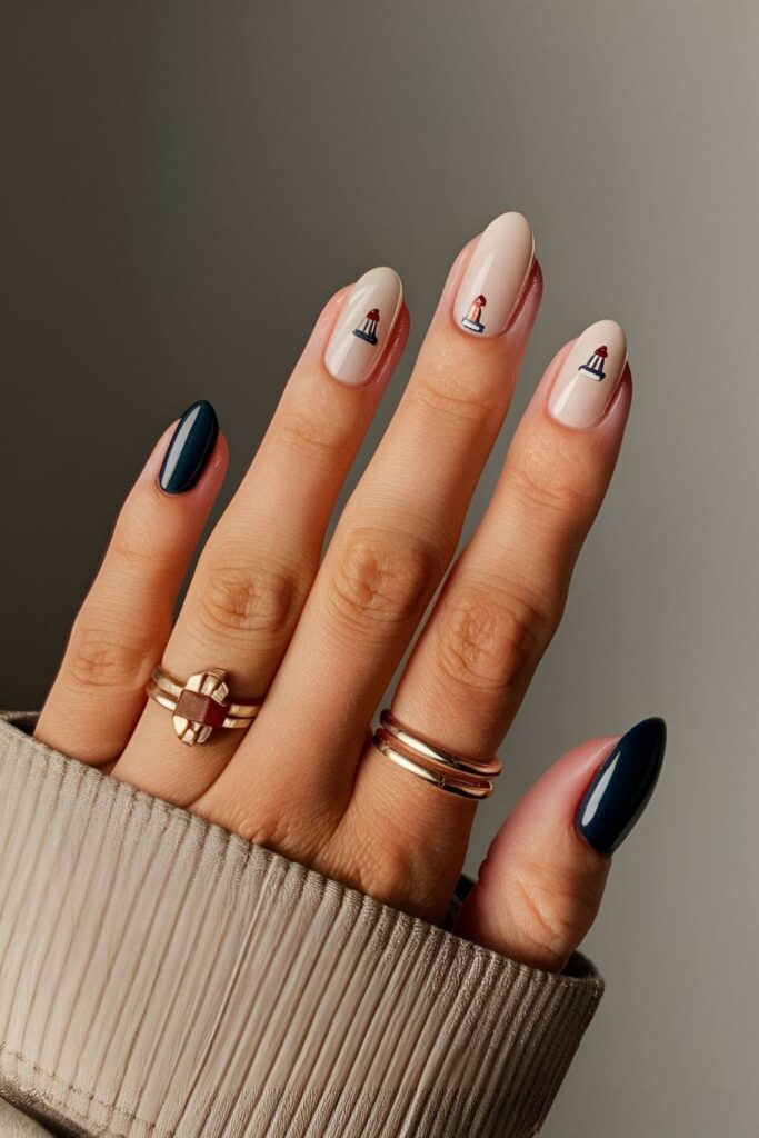 Neutral base nails with small lighthouse shapes in navy blue, white, or metallic shades for a charming and nautical minimalist look