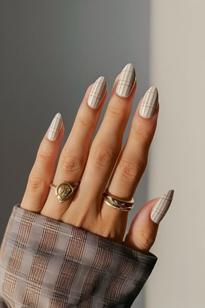 Neutral base nails with thin plaid lines in black or white, forming a subtle and sophisticated plaid pattern