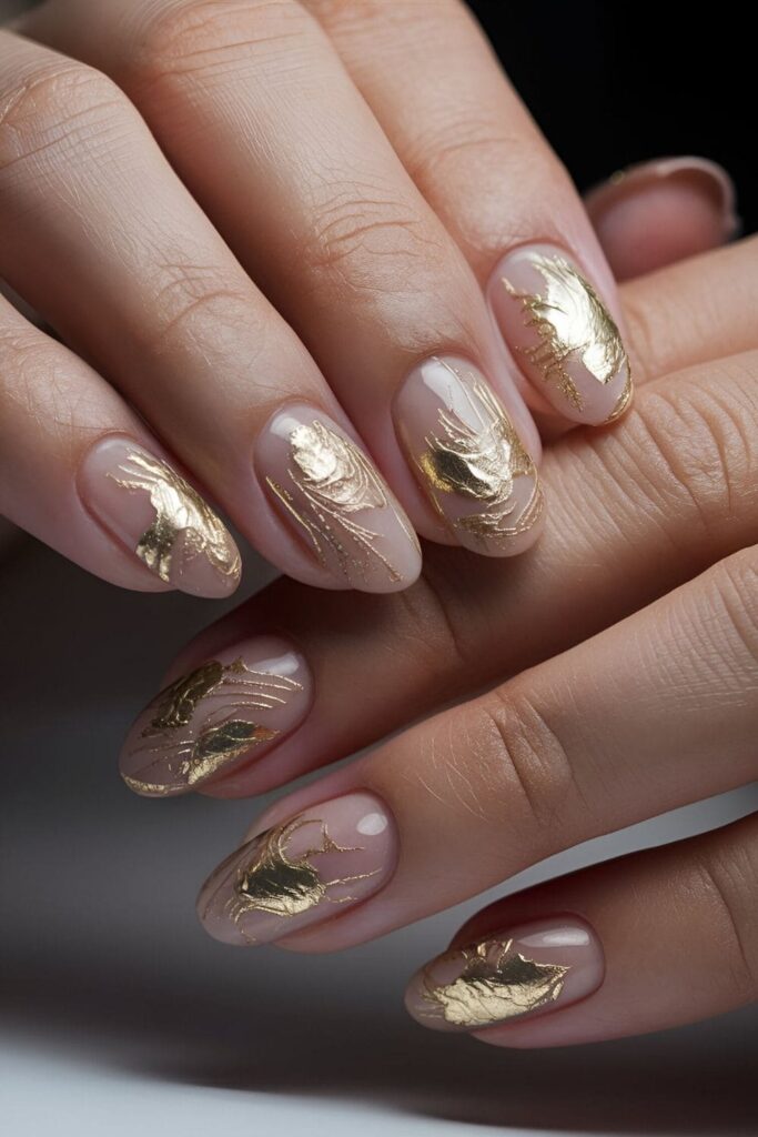 Opulent gold leaf accents on nails over a nude or dark base color