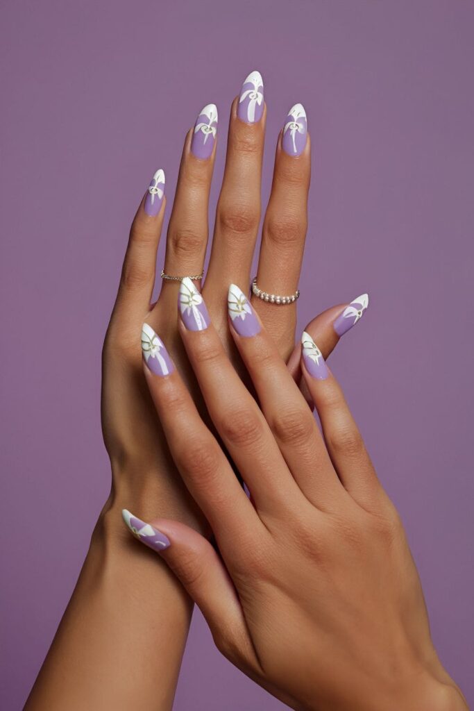 Pale lavender nails with delicate white orchid designs and subtle silver accents for an elegant look