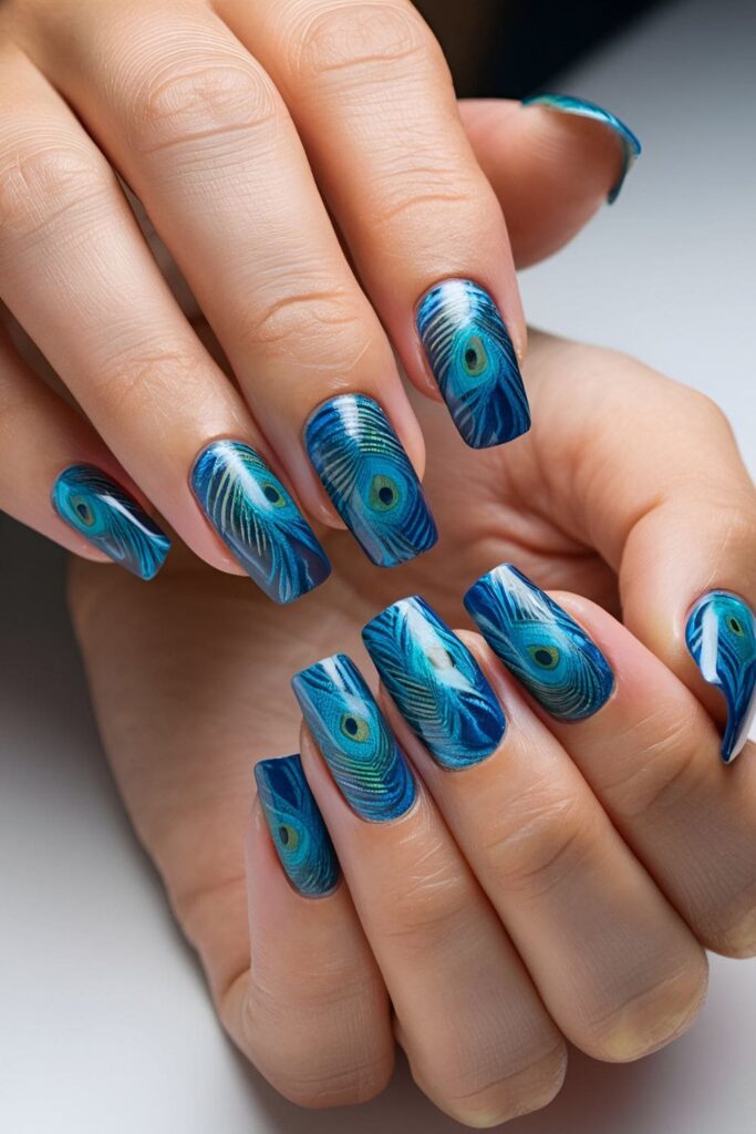 Peacock feather nail art in blue and green hues