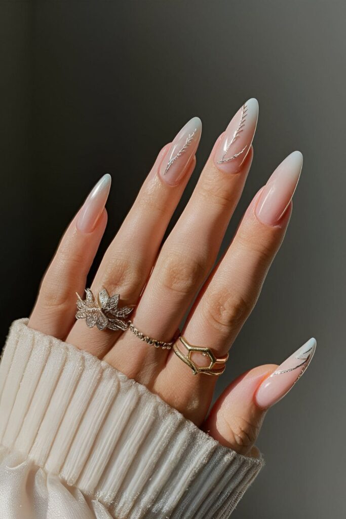 Pearly white nails with delicate silver or gold feather-like designs, mimicking angel wings