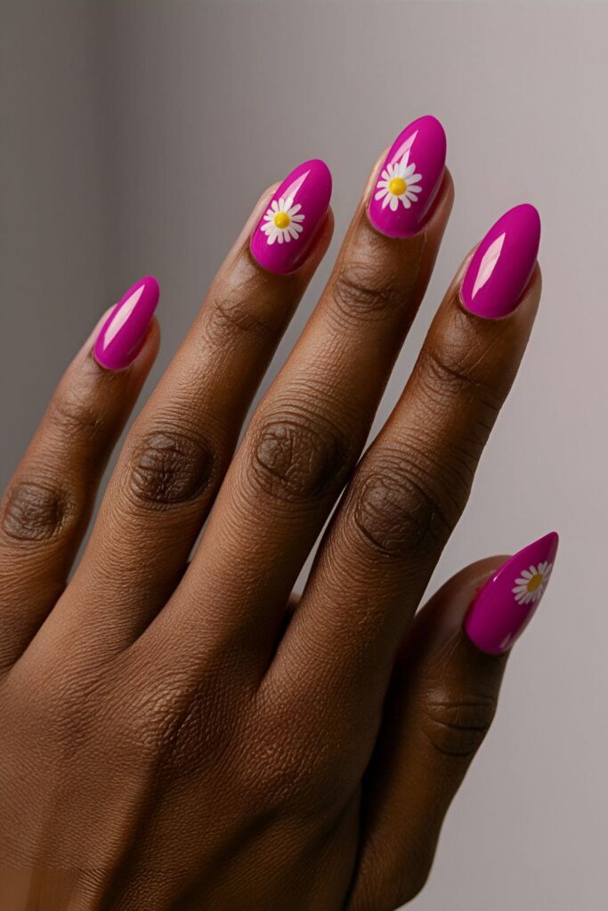 Pink acrylic nails adorned with white daisy flowers, creating a cheerful and fresh look that complements dark skin tones