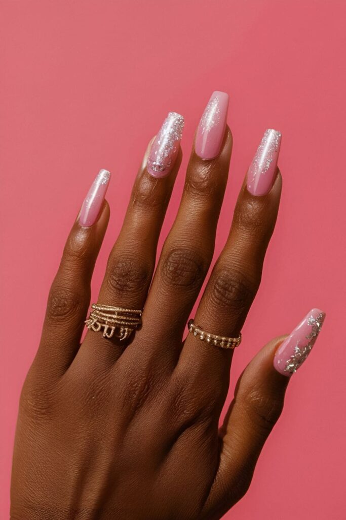 Pink acrylic nails with silver glitter accents, adding a glamorous and sparkling touch for dark skin tones