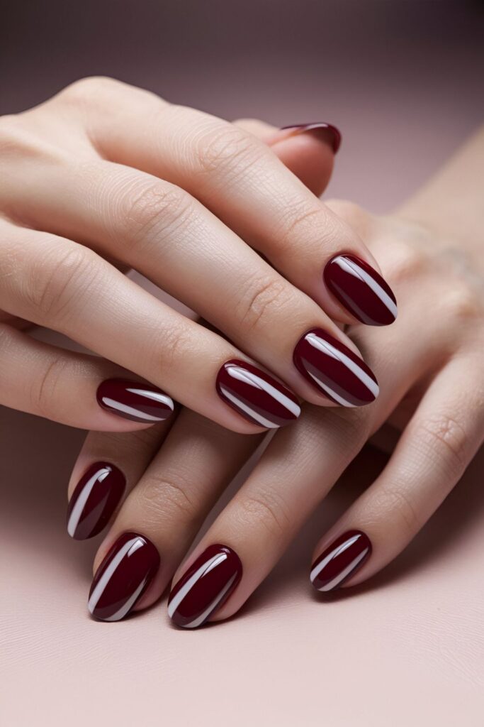 Red manicure with crisp white stripes arranged horizontally or vertically, evoking a nautical theme