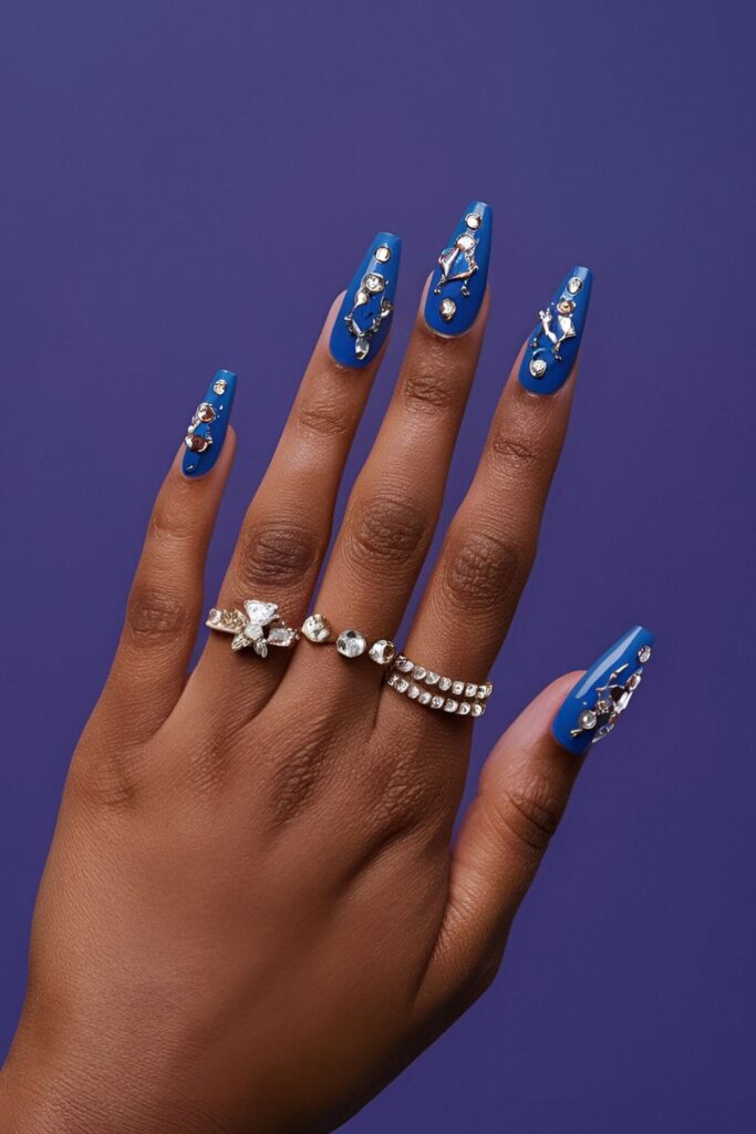 Royal blue acrylic nails adorned with sparkling rhinestones