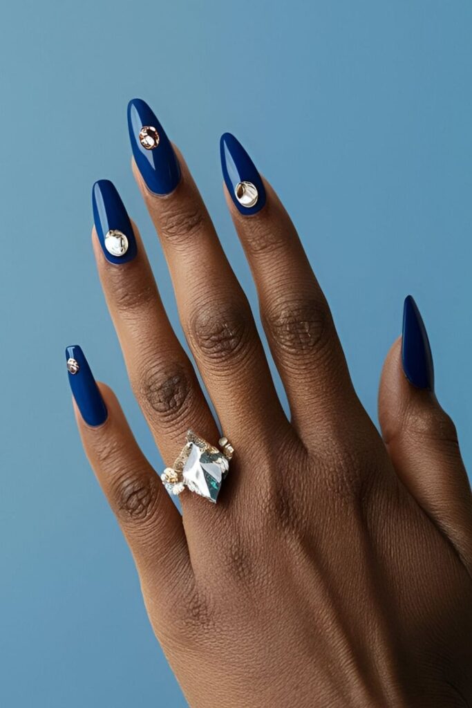 Royal blue nails adorned with strategically placed jewels and gems, adding extra sparkle and making the nails a focal point with dazzling embellishments