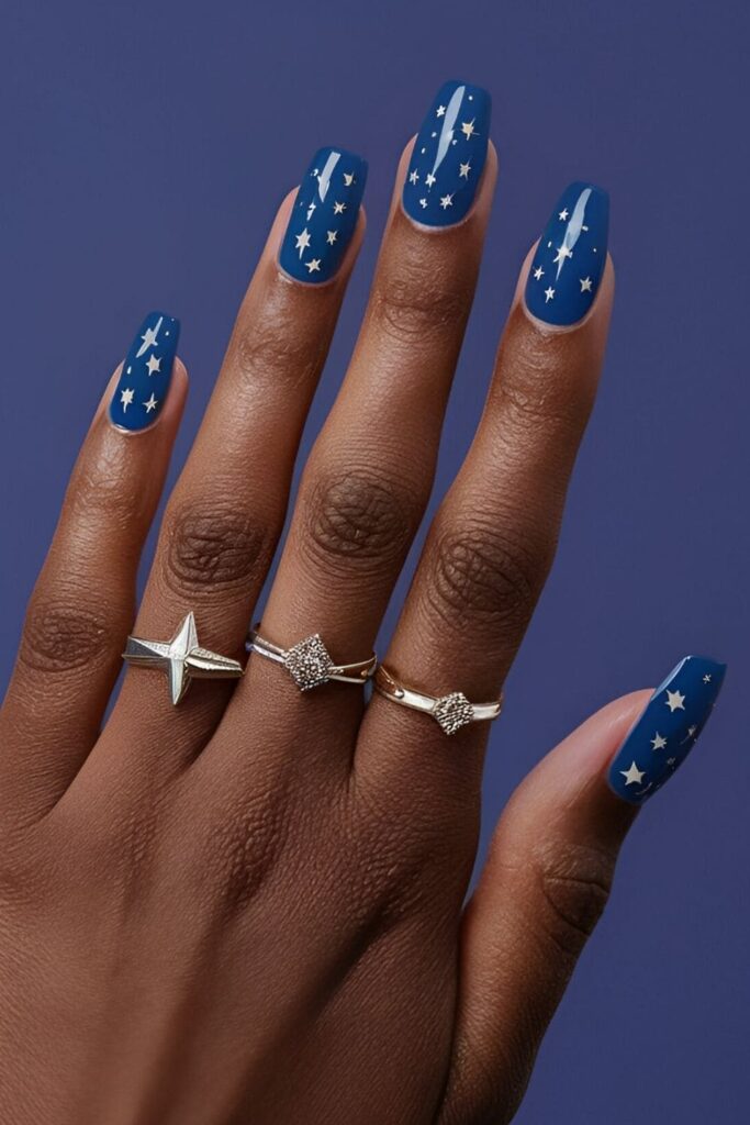 Royal blue nails adorned with tiny silver stars, creating an enchanting celestial design perfect for a starry night theme