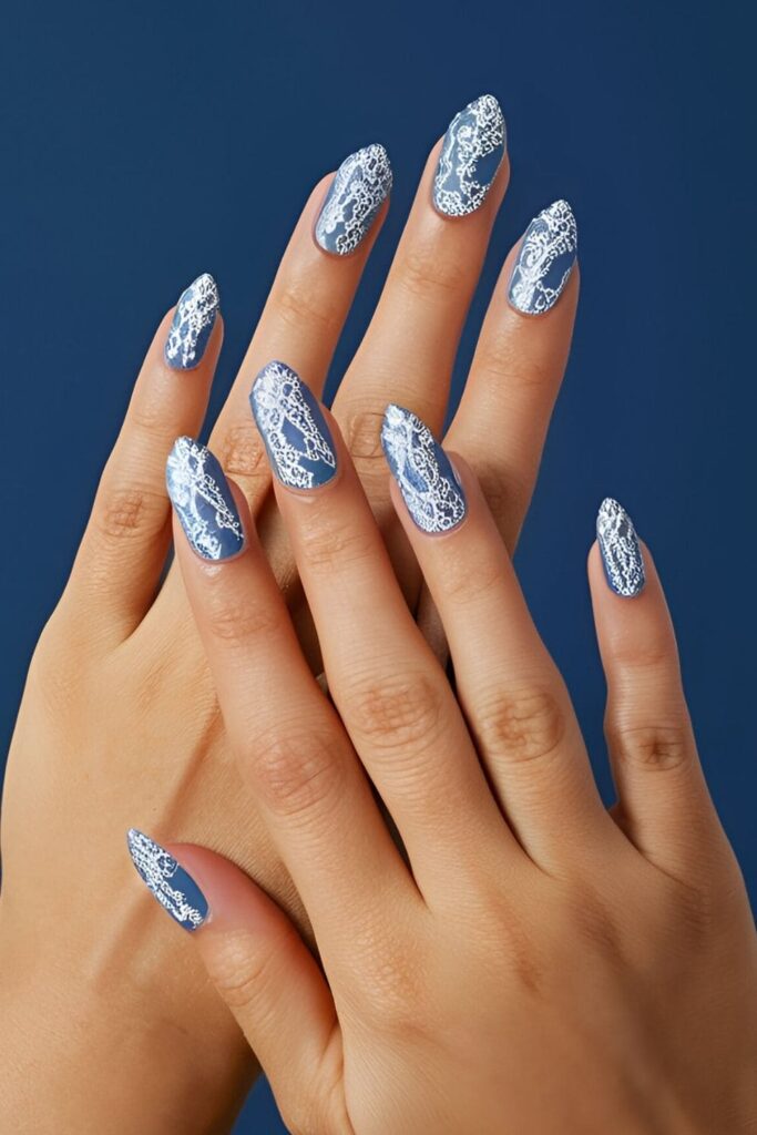 Royal blue nails featuring intricate white or silver lace patterns, adding sophistication and vintage elegance with delicate lace designs