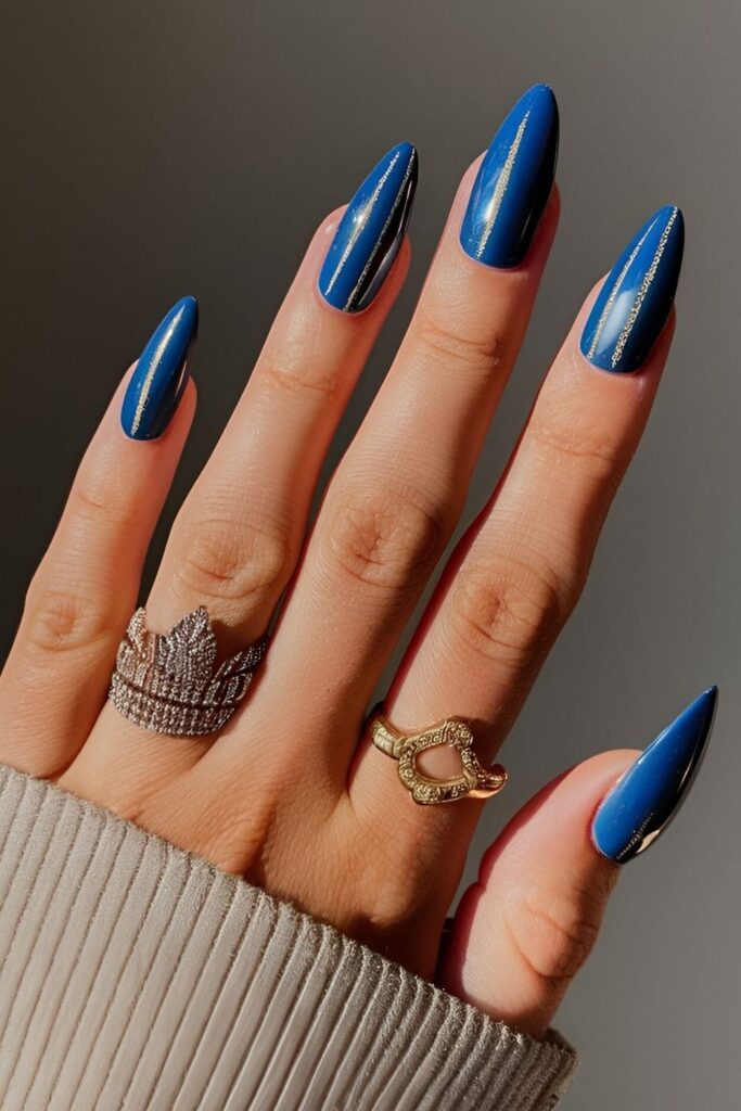 Royal blue nails with gold or silver stripes, dots, or shapes, creating a luxurious and regal appearance with shiny metallic accents