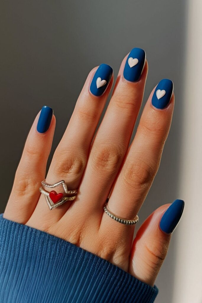 Royal blue nails with tiny heart accents in white, silver, or red, adding a touch of romance and playfulness with cute heart designs