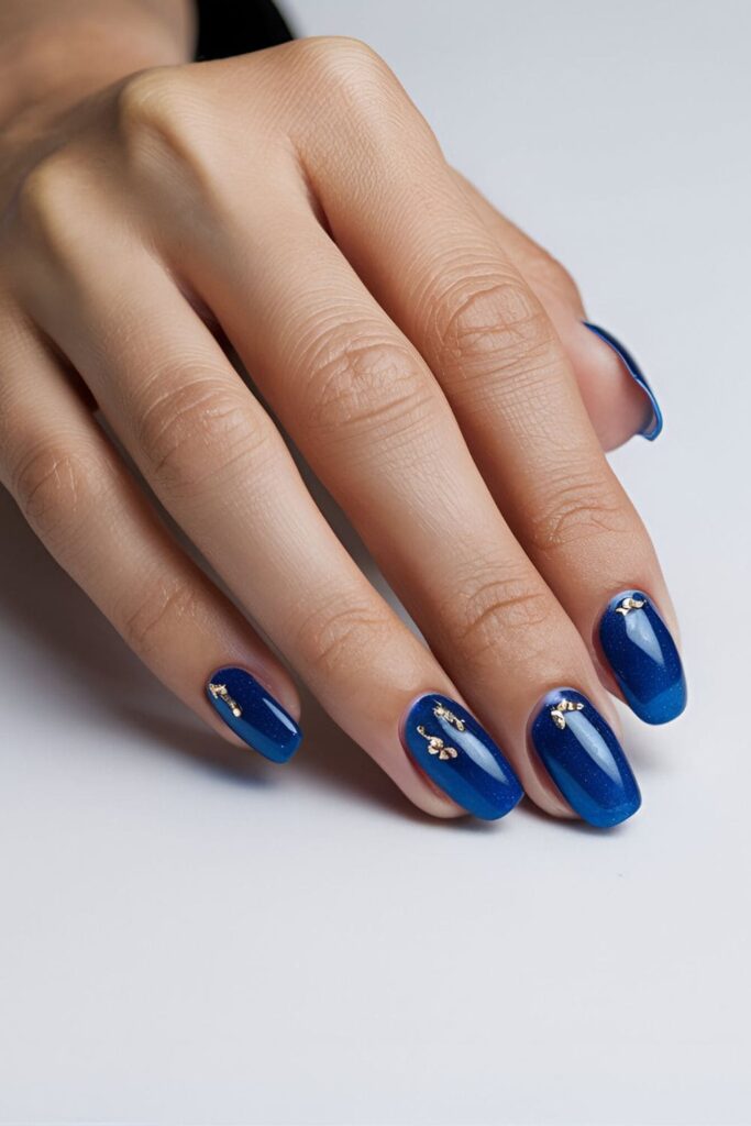 Sapphire blue acrylic nails with luxurious gold accents