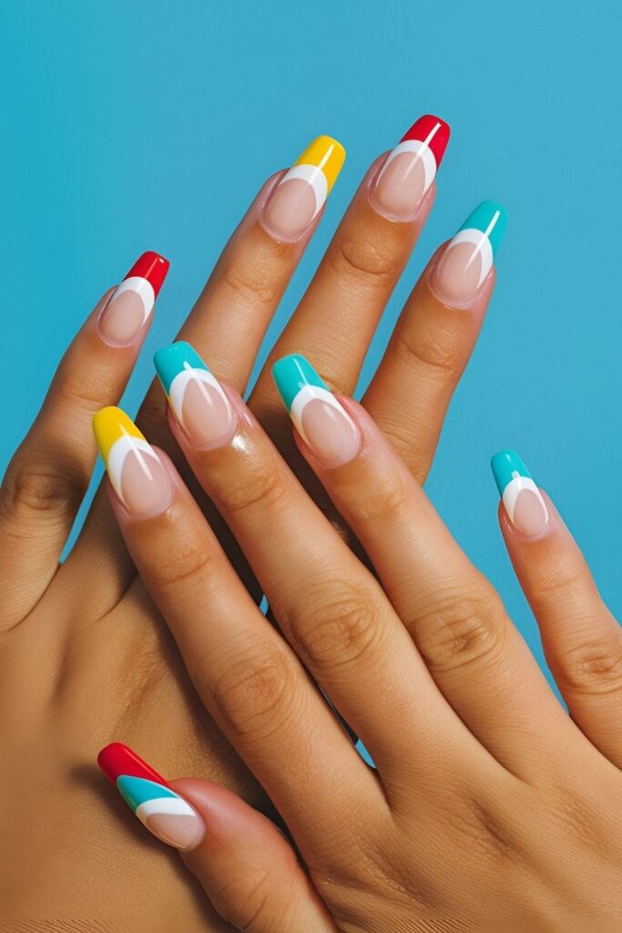 Short acrylic nails with beach ball-inspired tips in red, yellow, blue, and green stripes, fun and summery