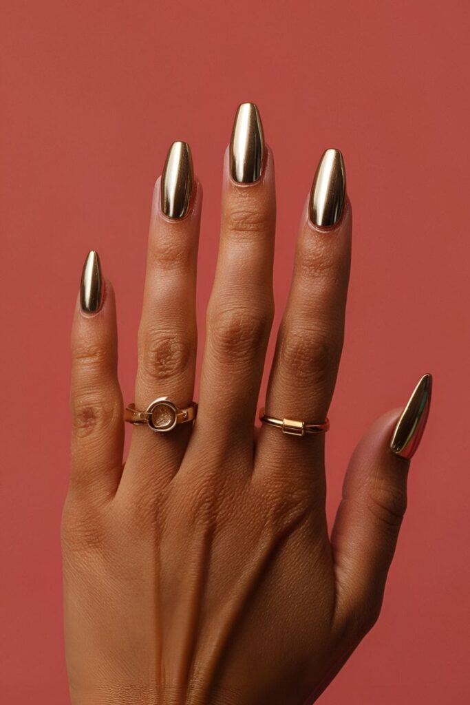 Sleek and futuristic gold chrome acrylic nails with a metallic finish, perfect for a bold, high-fashion look