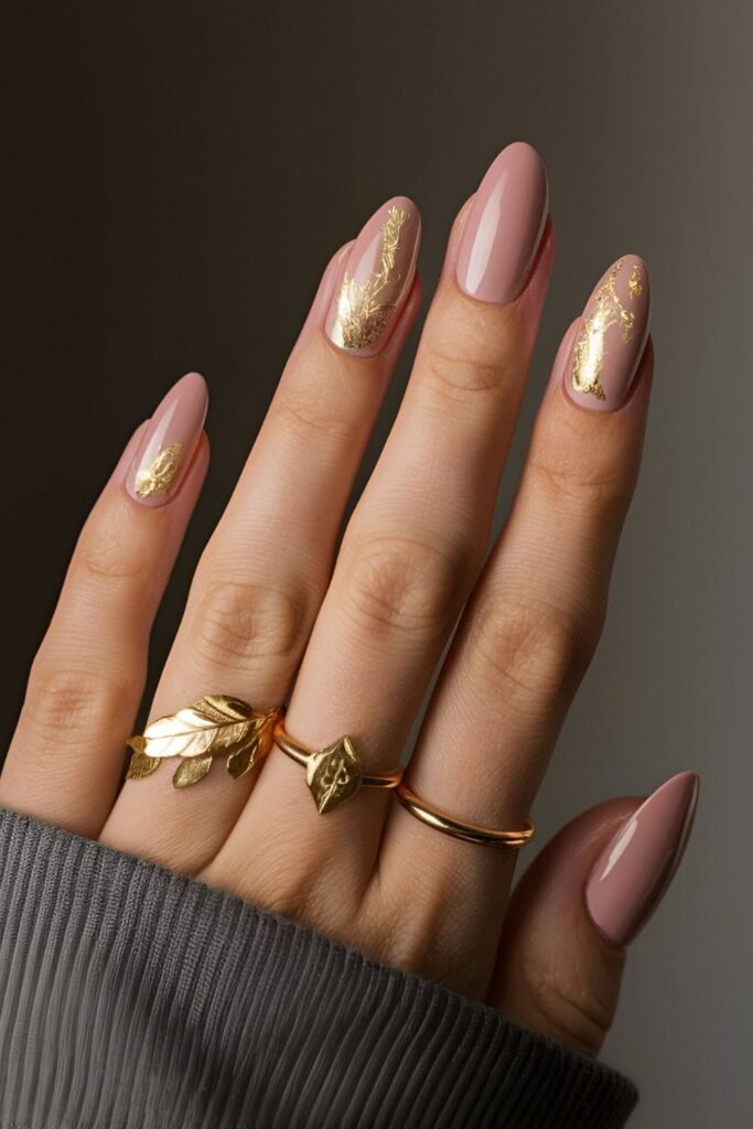 Soft pink nails with rich gold leaf accents, combining elegance and luxury for fall