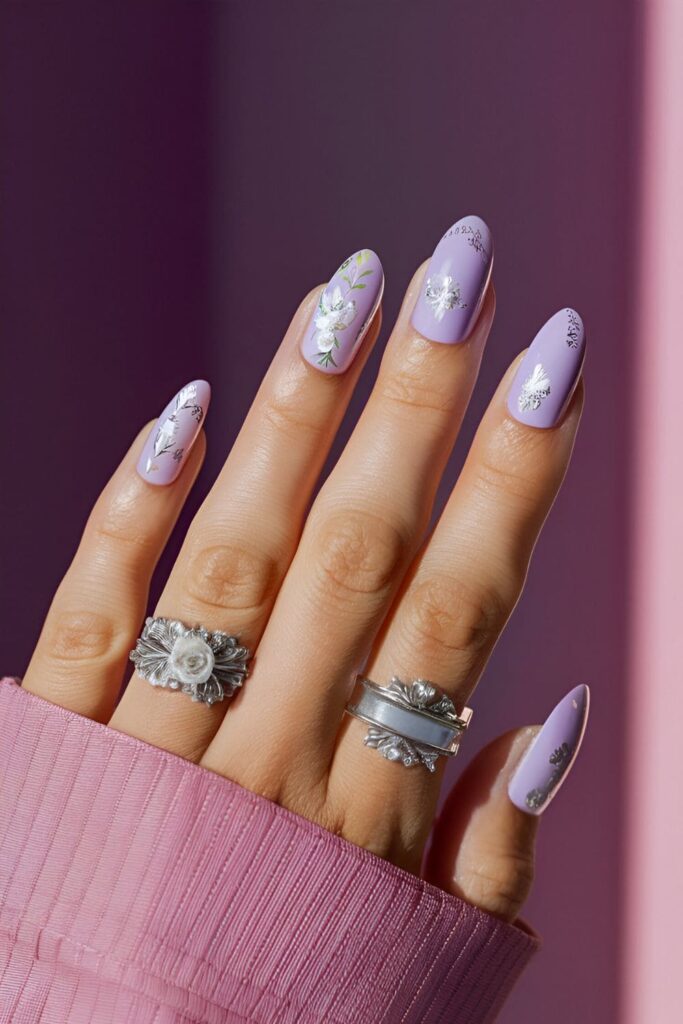 Soft pink or lavender nails with delicate white floral patterns and silver accents, creating a moonlit garden effect