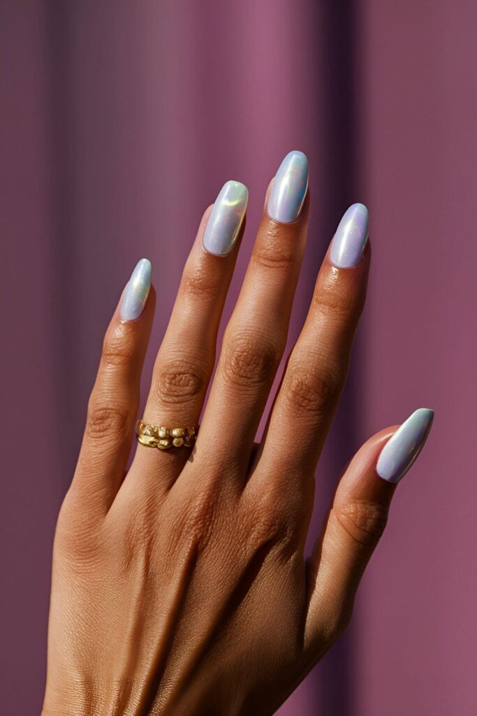 Soft white or nude nails with hints of pink, blue, and green, featuring an iridescent finish for a magical opal look