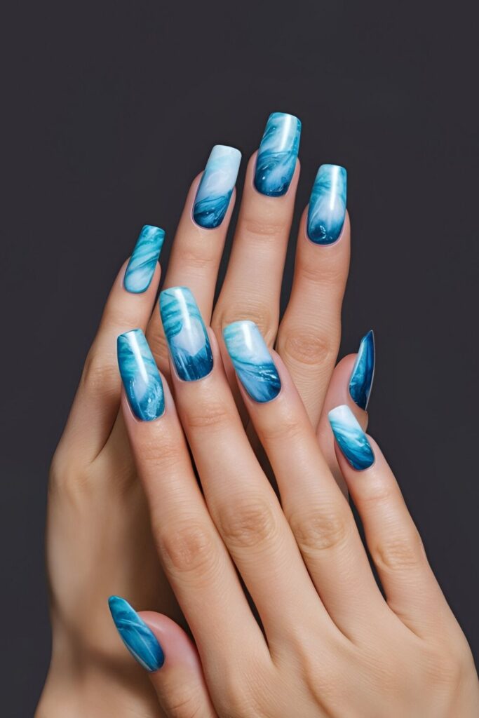 Soothing-nails-with-varying-shades-of-blue-swirling-together-like-ocean-waves-perfect-for-beach-days-and-summer-parties