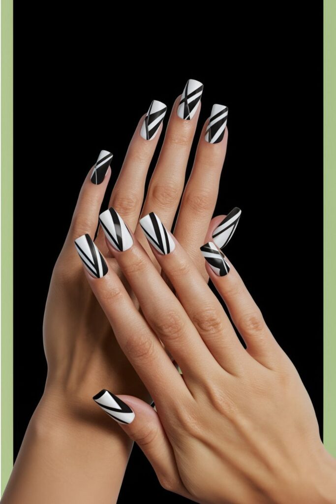 Stylish acrylic nails with bold geometric patterns in contrasting colors, positioned against a black and green backdrop