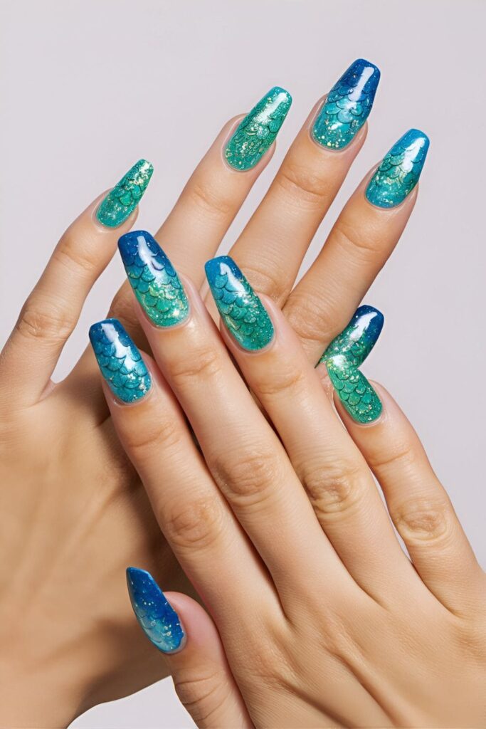 Whimsical blue acrylic nails with mermaid scale patterns in various shades