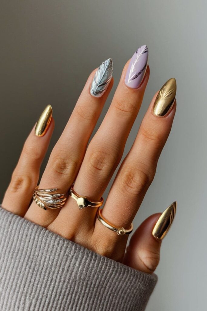 Whimsical gold acrylic nails with delicate feather designs in pastel and metallic polish, ideal for a feminine look