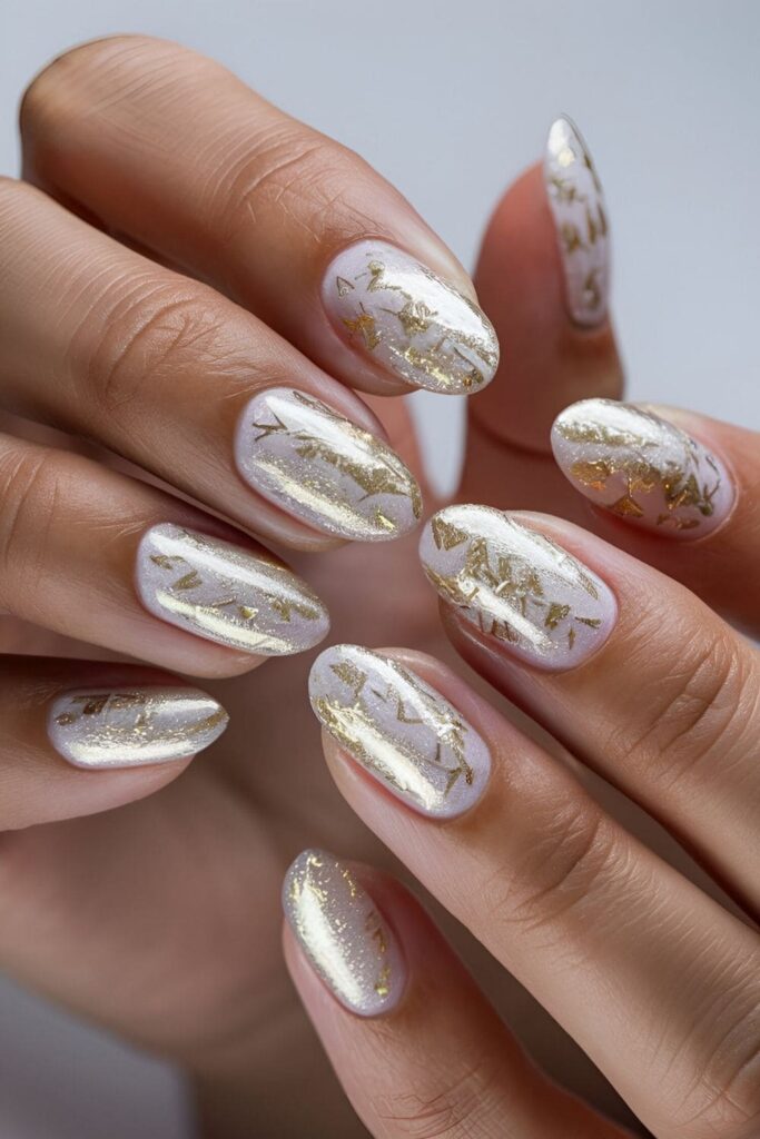 White nails adorned with delicate gold flakes