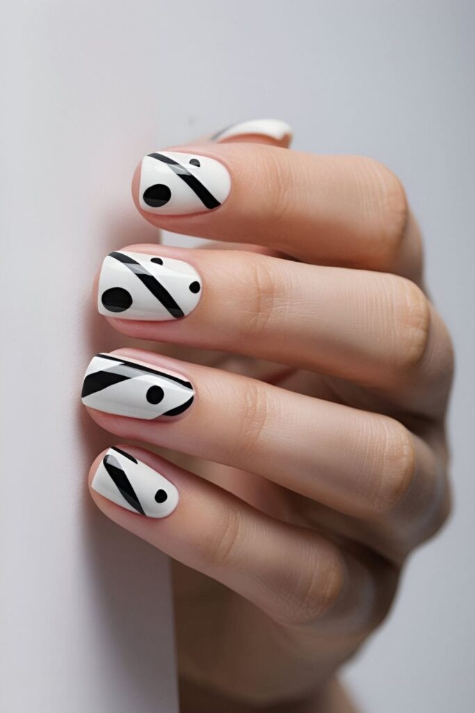 White nails with striking black stripes, dots, or geometric shapes