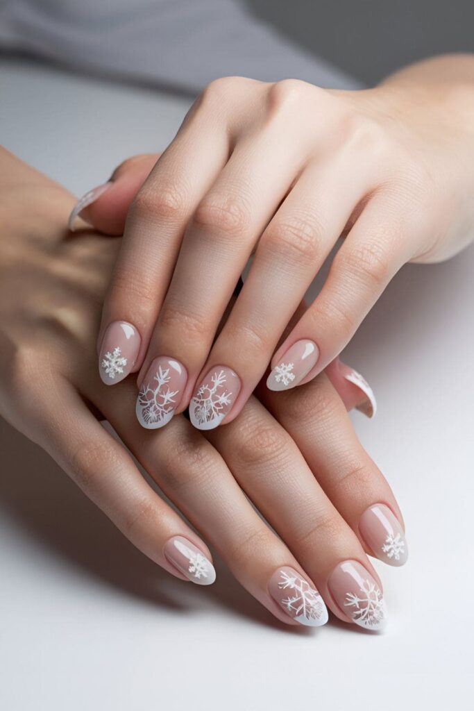 Winter-themed nails with delicate hand-painted snowflakes or snowflake decals on a light, frosty base