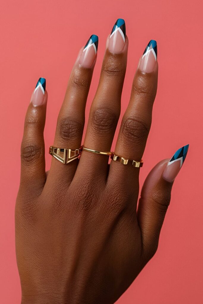 Dark-skinned hands with negative space acrylic nails, showcasing bold colors and metallic geometric patterns