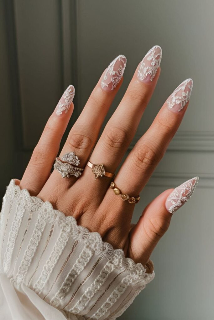 Acrylic nails featuring detailed, embroidery-style designs inspired by bridal gowns