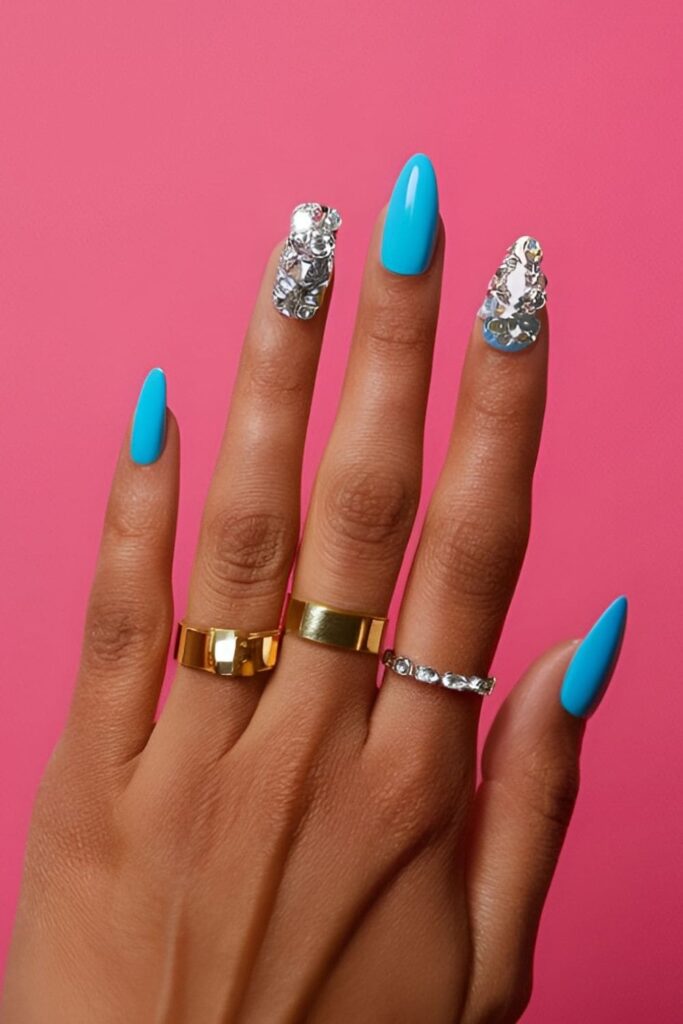 Bold acrylic nails featuring neon shades, glitter polishes, and large rhinestones, making a vibrant and statement-making look