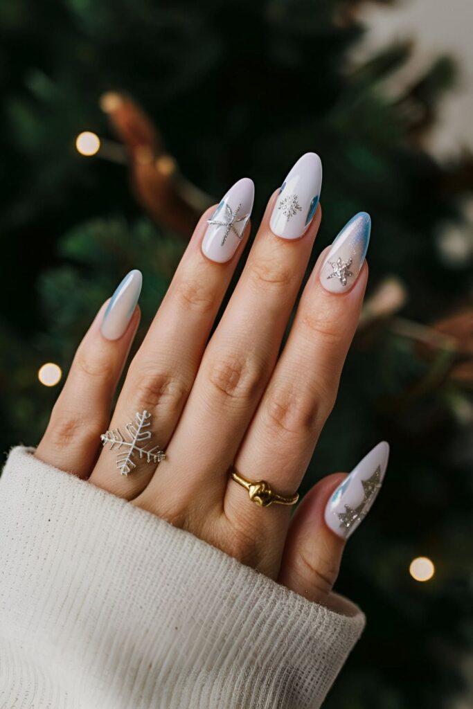 Acrylic nails in shades of white, blue, and silver, featuring snowflakes, icicles, and frosty designs