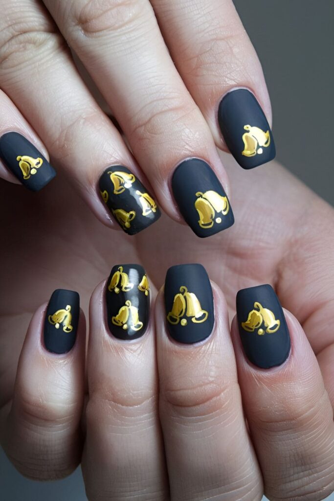 Acrylic nails with tiny golden bell accents on one or two nails, featuring intricate details