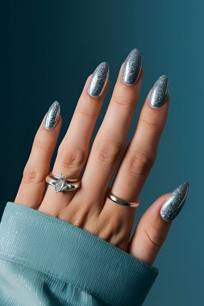 Ice blue nails with silver glitter accents, mimicking shimmering ice crystals under a glossy finish