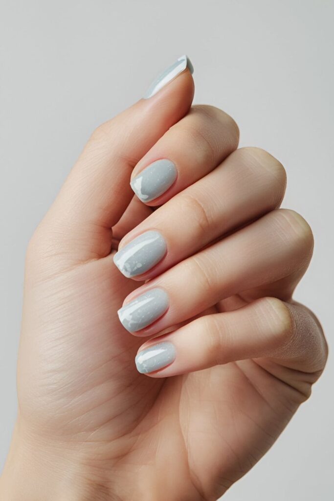 Light blue nails with frosted white tips, resembling the look of freshly fallen snow on a cold winter day