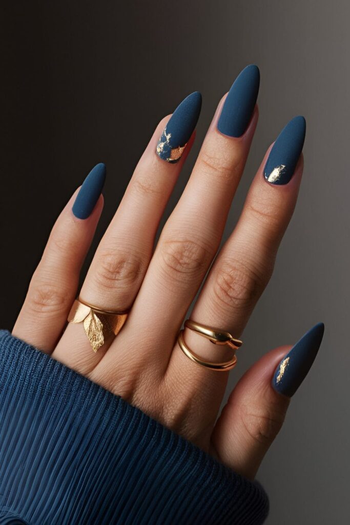 Matte velvet blue nails with gold leaf details, offering a rich and cozy winter aesthetic