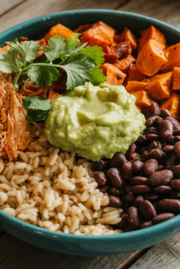 Chipotle shredded chicken bowl with roasted sweet potatoes, black beans, brown rice, and guacamole