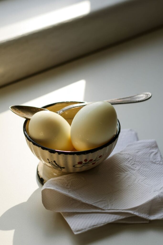 Peeled hard-boiled eggs in a snack container with salt for a protein-packed school snack