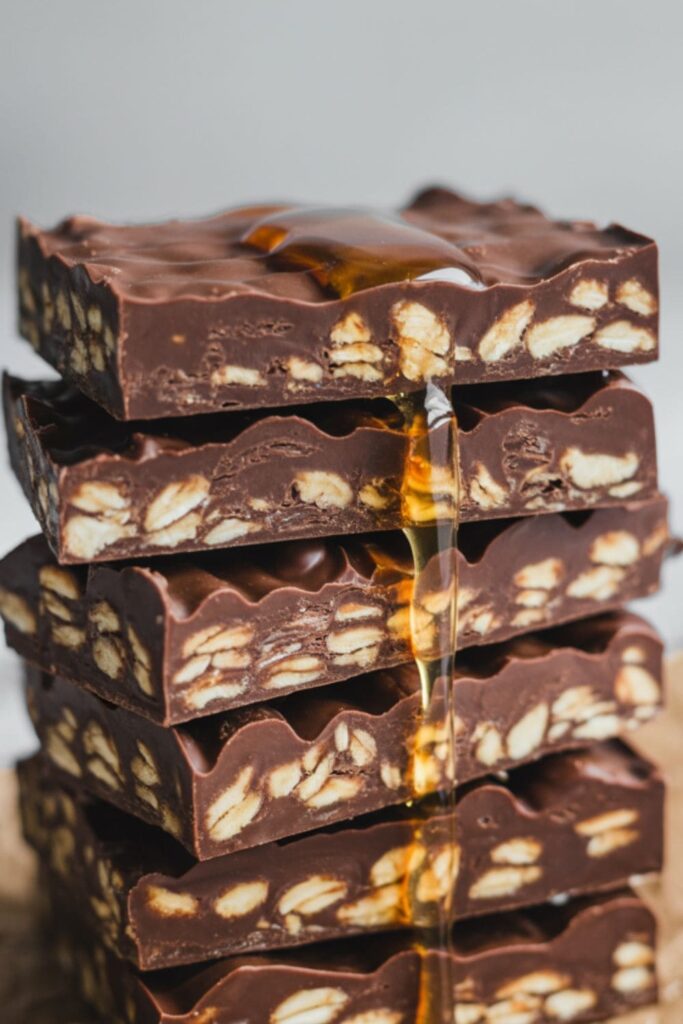 Stack of no-bake chocolate oat bars on parchment paper