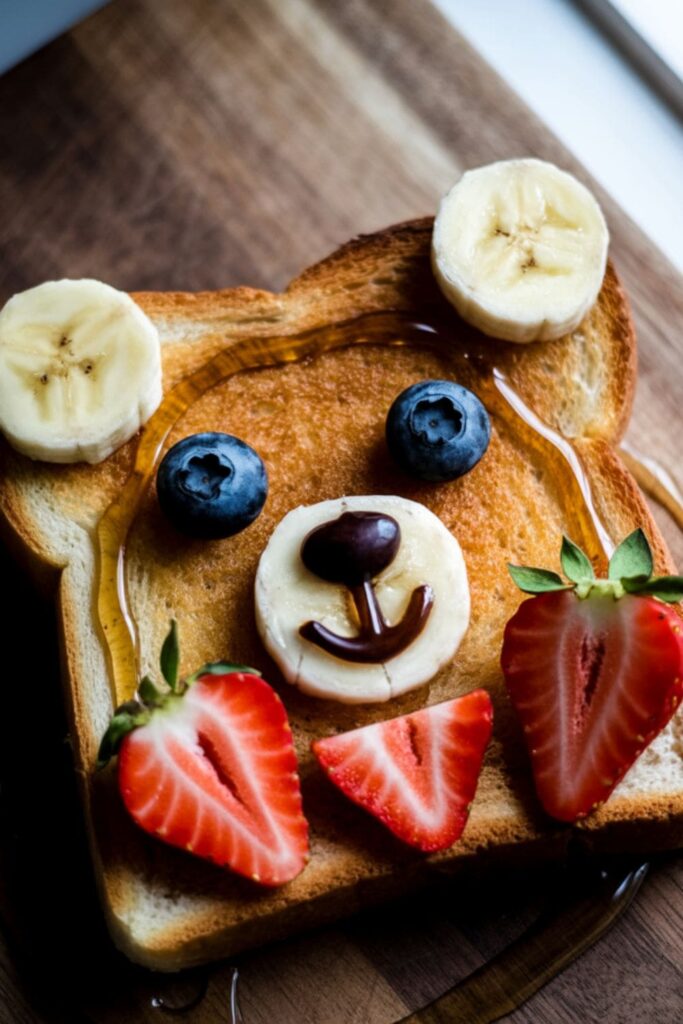 Toast slice decorated with fruit to look like a bear face